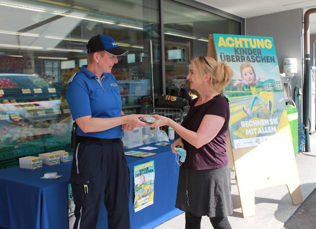 Nicole Strüver, Leiterin Verkehrsinstruktion der Polizei Oberes Fricktal, überreicht einer Passantin in Kaisten ein Präsent. Es soll darauf aufmerksam machen, dass Kindern im Strasenverkehr erhöhte Aufmerksamkeit gebührt. Foto: Sonja Fasler