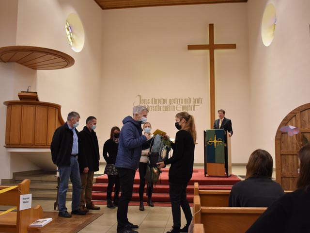 Kirchenpflegepräsident Claude Chautems überreicht ein Abschiedsgeschenk an Pfarrerin Claudia Speiser. Foto: zVg
