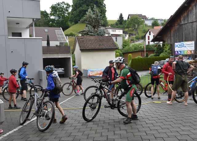 Es war ein Gewusel rund um den Wasserschlauch. Bikes und Teilnehmer befreiten sich vom Schlamm und von den Matsch-Schuhen (ganz rechts im Bild). Foto: Anja Hasler