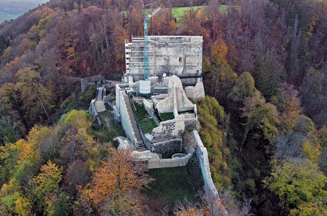  Die bis auf das Vorwerk sanierte Farnsburg, Stand November 2022. Blick von Nordosten auf die fertig gesicherte Oberburg mit Brunnenhaus, Amtshaus und Plas mit Schildmauer (von vorne nach hinten). Das noch nicht gesicherte Vorwerk ist im Hintergrund links der mächtigen Schildmauer zu erkennen. Foto: Kanton Basel-Landschaft