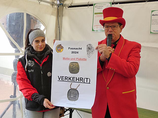 Der Narrenvater und Elferratsmitglied Tiffany Kuonen präsentieren das Motto und die Plakette der Fasnacht 2024. Foto: Jörg Wägli