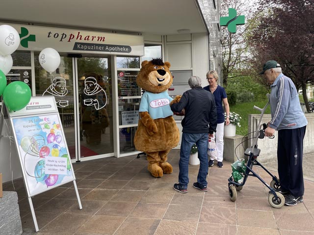 Maskottchen Tobi und Apothekerin Dr. Katrin Ellgehausen Forrer begrüssen die Gäste und Kunden vor dem Eingang der Kapuziner Apotheke. Foto: Lilia Staiger