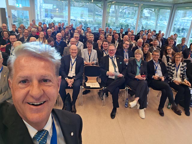 District Governor Christoph Blaser mit den Teilnehmenden im Saal des Hotel Schützen. Foto: zVg