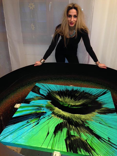 Die Spin-Art-Künstlerin Anastasia Rychen mit einem ihrer farbenprächtigen Bilder. Foto: zVg