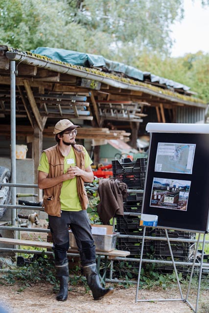 Landwirt Leander Dalbert zeigt den Anwesenden die angelegte Keyline und erklärt, wie er damit wirtschaftliche Produktion, Biodiversität und Wasserrückhaltung zusammenbringt.
