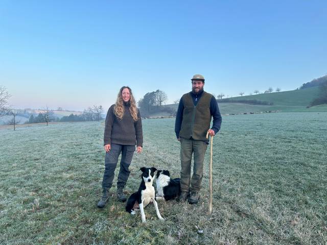 Traumhaftes Wetter am Morgen: Die Wanderhirten Lea König und Marc Engstler haben während ihrer bald dreimonatigen Tour auch anderes erlebt. Die Hunde sind schon ganz aufgeregt. Während sich Maid, ganz Dame, noch schnell fürs Foto in Pose wirft, ist Glen schon voll im Arbeitsmodus und hat die Herde im Hintergrund ganz genau im Auge. Foto: Sonja Fasler